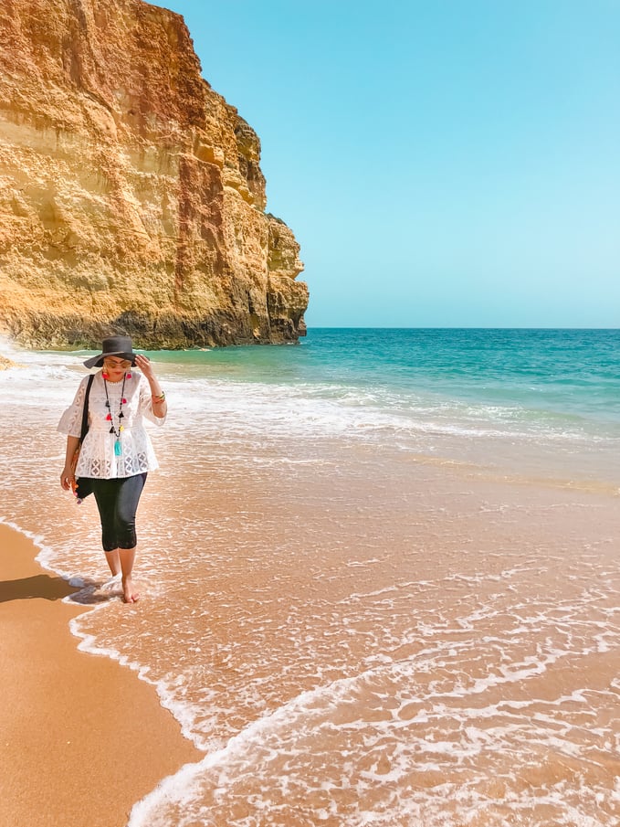 Muslim blogger on beach with cliffs