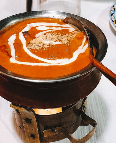 Red-orange butter chicken in pot