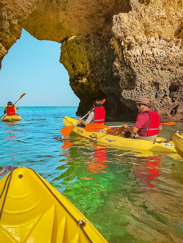 Friends on yellow kayak exiting cave