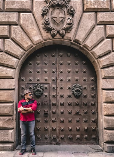 Muslim man in red shirt next to door in Gothic Quarter