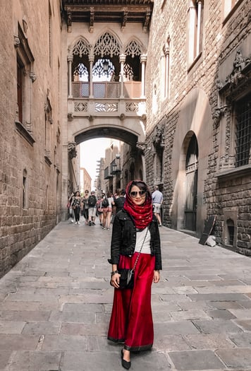 Muslim blogger wearing red pants in Gothic Quarter alley