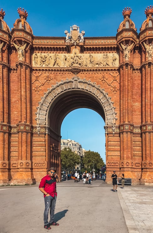 Muslim man wearing red shirt beside Arc de Triomf