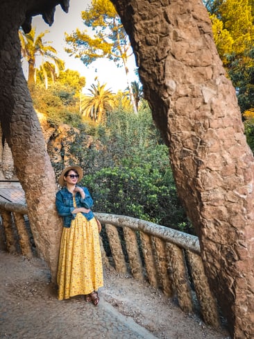 Muslim blogger standing in yellow dress at Park Guell