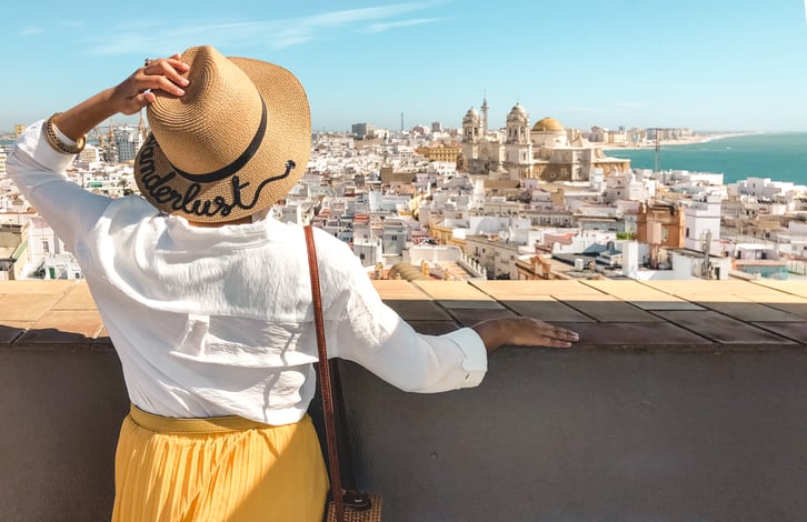 Muslim travel blogger wearing sun hat looking at Cadiz's skyline from Tavira Tower