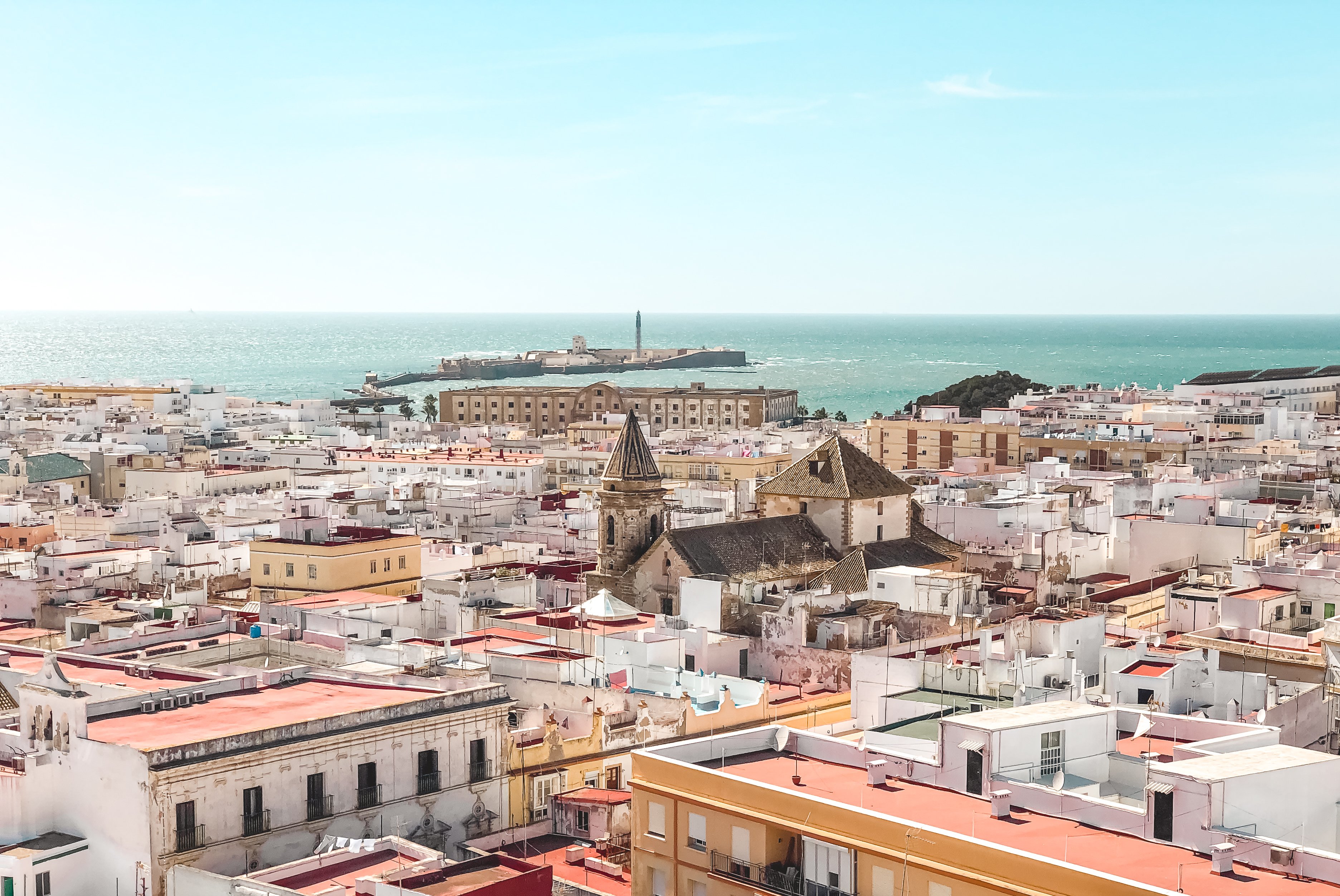 Watchtower in Cadiz surrounded by white buildings with water in the distance