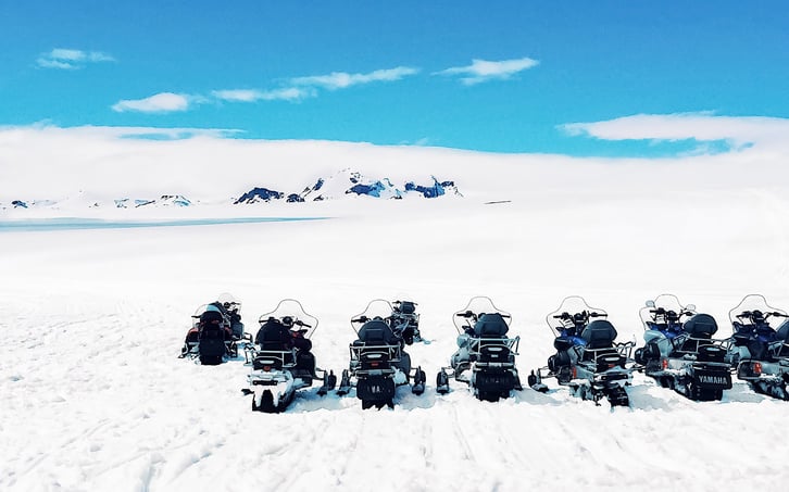 Snowmobiles parked on snow-covered glacier