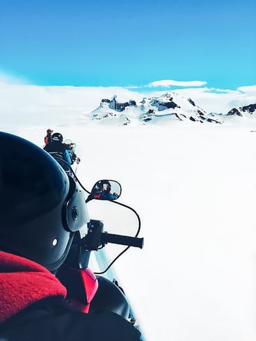 Snowmobiling tour on snow-covered glacier