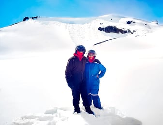 Muslim travel couple in snow suits on snowy glacier