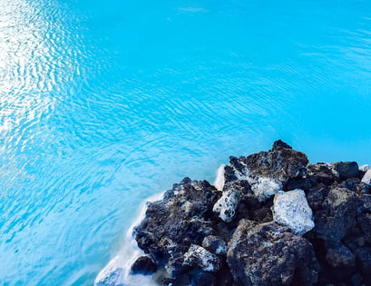 Blue water of Blue Lagoon with black rocks