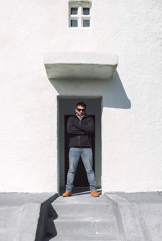 Man in black jacket in front of lighthouse