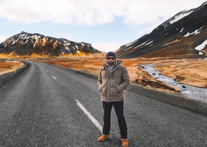 Man in brown jacket standing on Iceland road