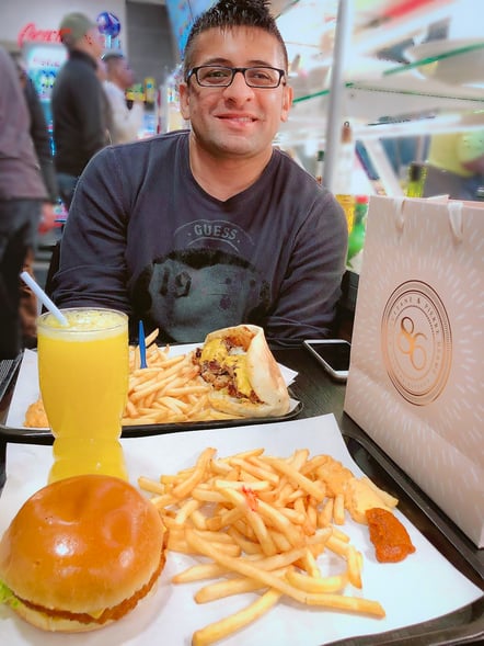 Muslim man eating halal burger and fries in Paris