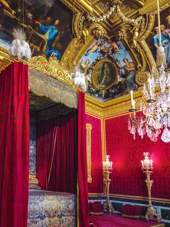 Four poster bed and mural ceiling inside Palace of Versailles
