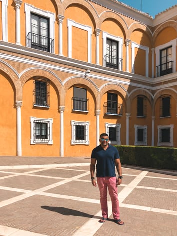 Man standing in front of golden arches of Seville Alcazar