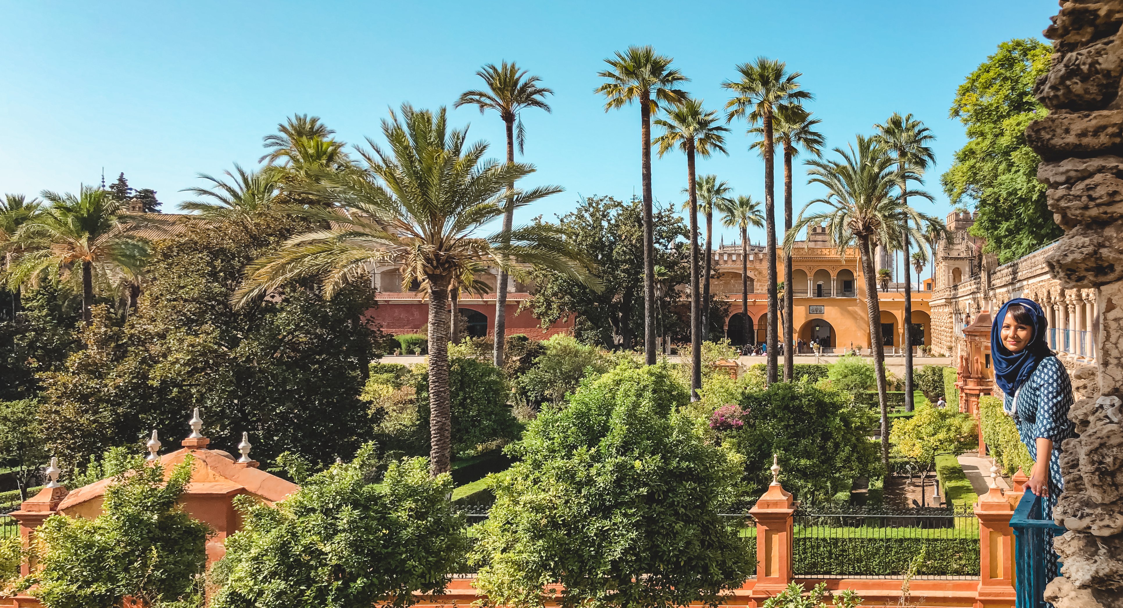 Muslim woman on balcony overlooking gardens of Seville Alcazar