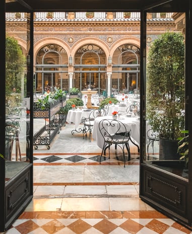 Black doors leading to dining courtyard in Seville hotel