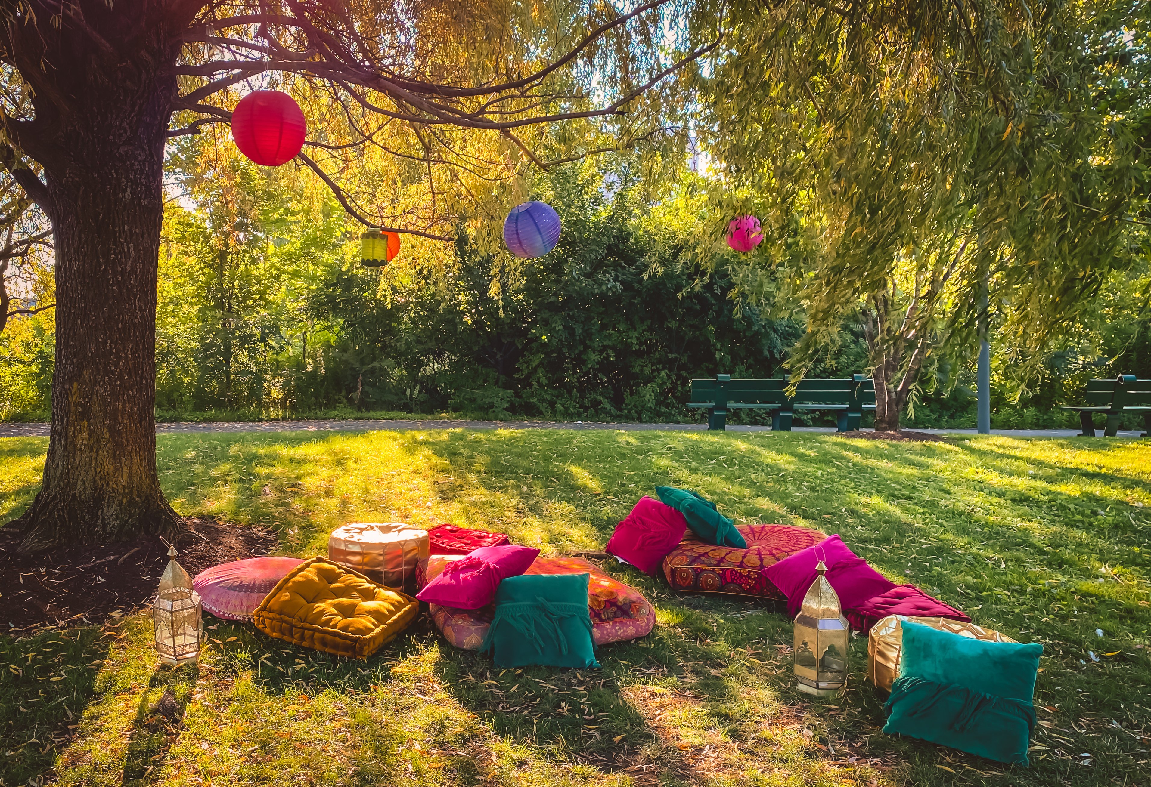 Colorful hanging lanterns and cushions in park for Eid