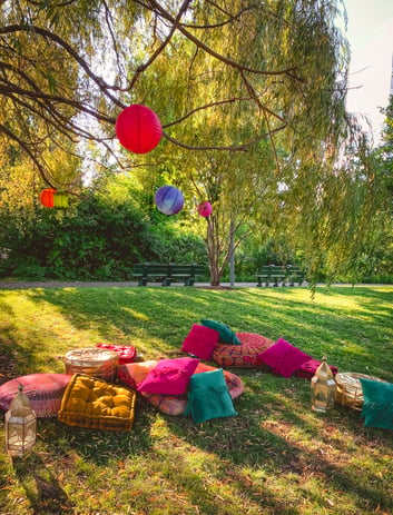 Colorful floor cushions strewn in park for Eid party